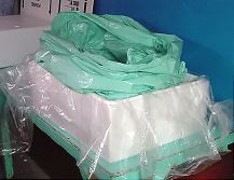 Multiple
        layers of heavy plastic bags, placed inside each other, are put inside plastic sheeting.